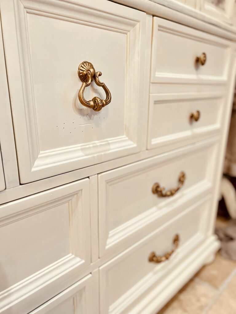 French country bedroom dresser mirror armoire furniture makeover dark antique walnut wrought iron accents home décor improvement chalk paint all in one wax glaze antique restoration before and after Provincial white cream gilding wax gold techniques tips Rae Dunn Disney Princess Mug Cinderella Bibbidi Bobbidi Boo
