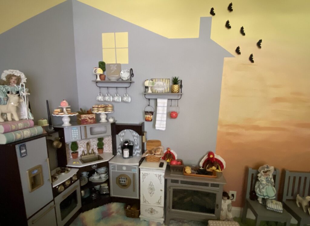 Halloween playroom decorations with bats flying over painted chimney on sunset wall